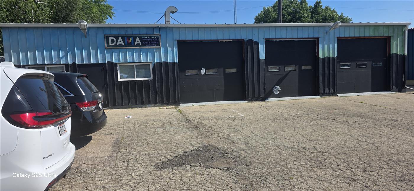 The exterior of DAMA headquarters on Allis Avenue, a low blue and black building with its sign above the door.